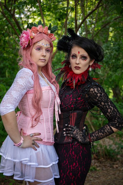 Free Two women in elaborate fantasy costumes pose in a park setting, showcasing intricate makeup and accessories. Stock Photo