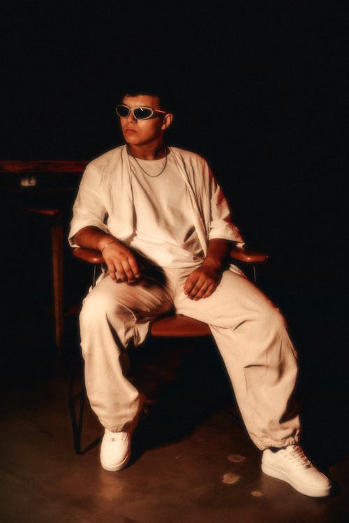 Man in White Clothes Sitting and Posing on Chair