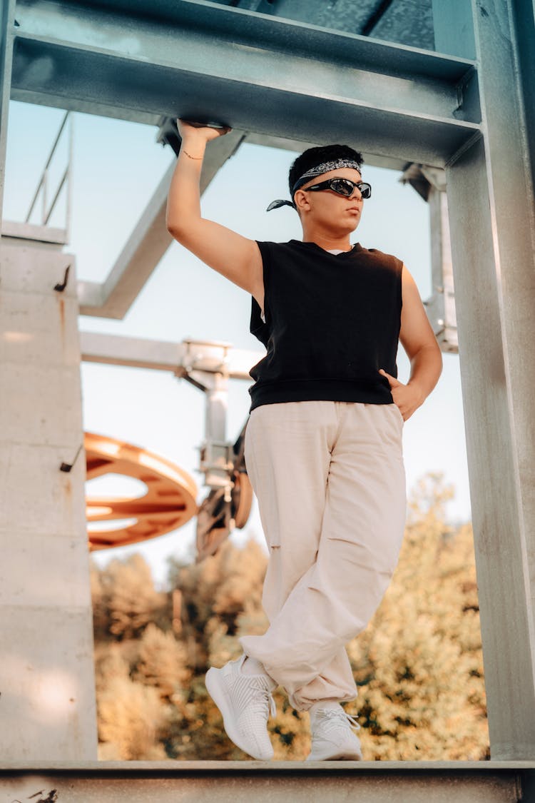 Young Man Posing In Black Tank Top And Beige Sweatpants