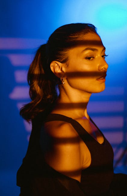 Artistic portrait of a woman with dramatic shadows in a studio setting.