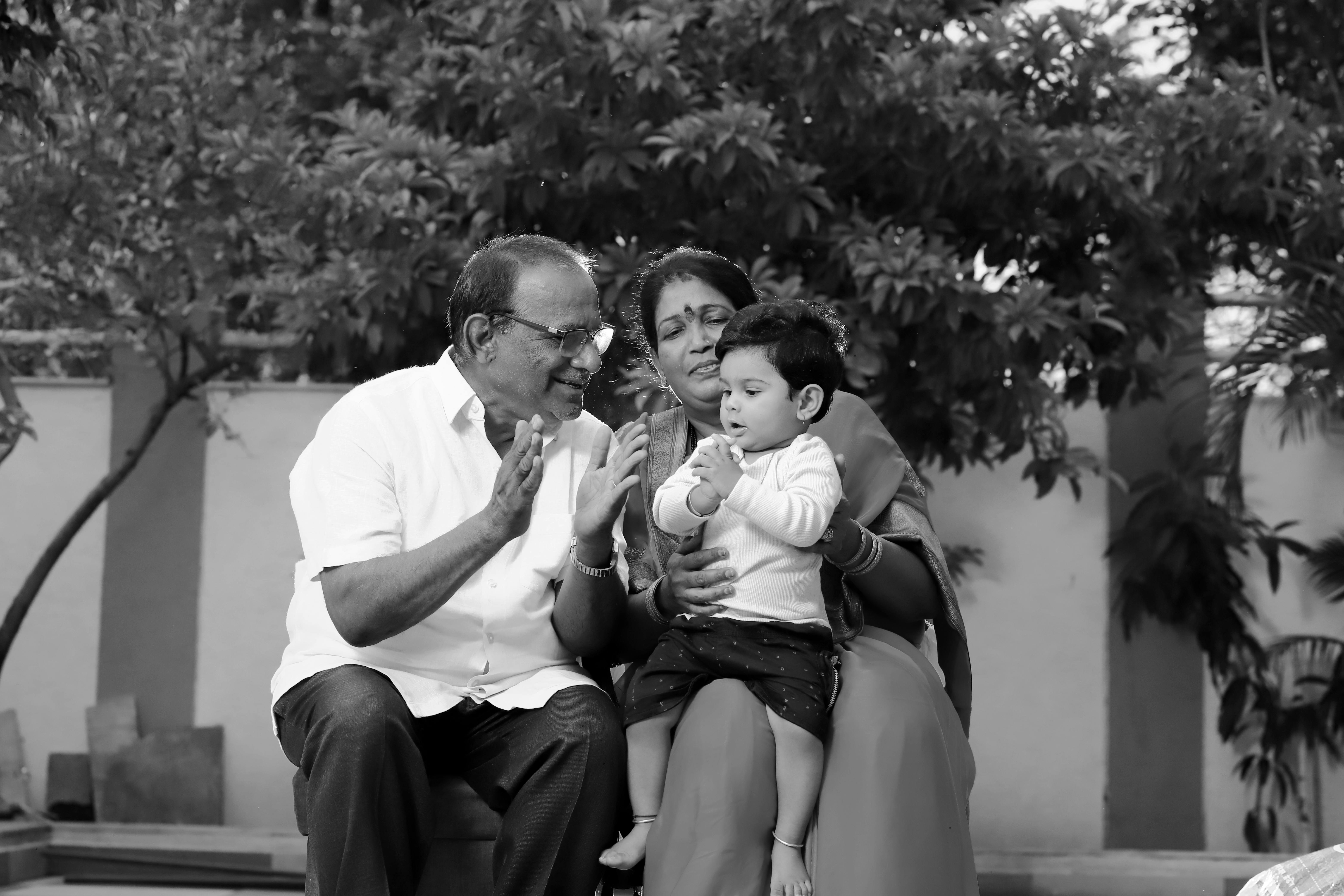 A black and white portrait of a South Asian family enjoying a moment together outdoors in Malegaon.