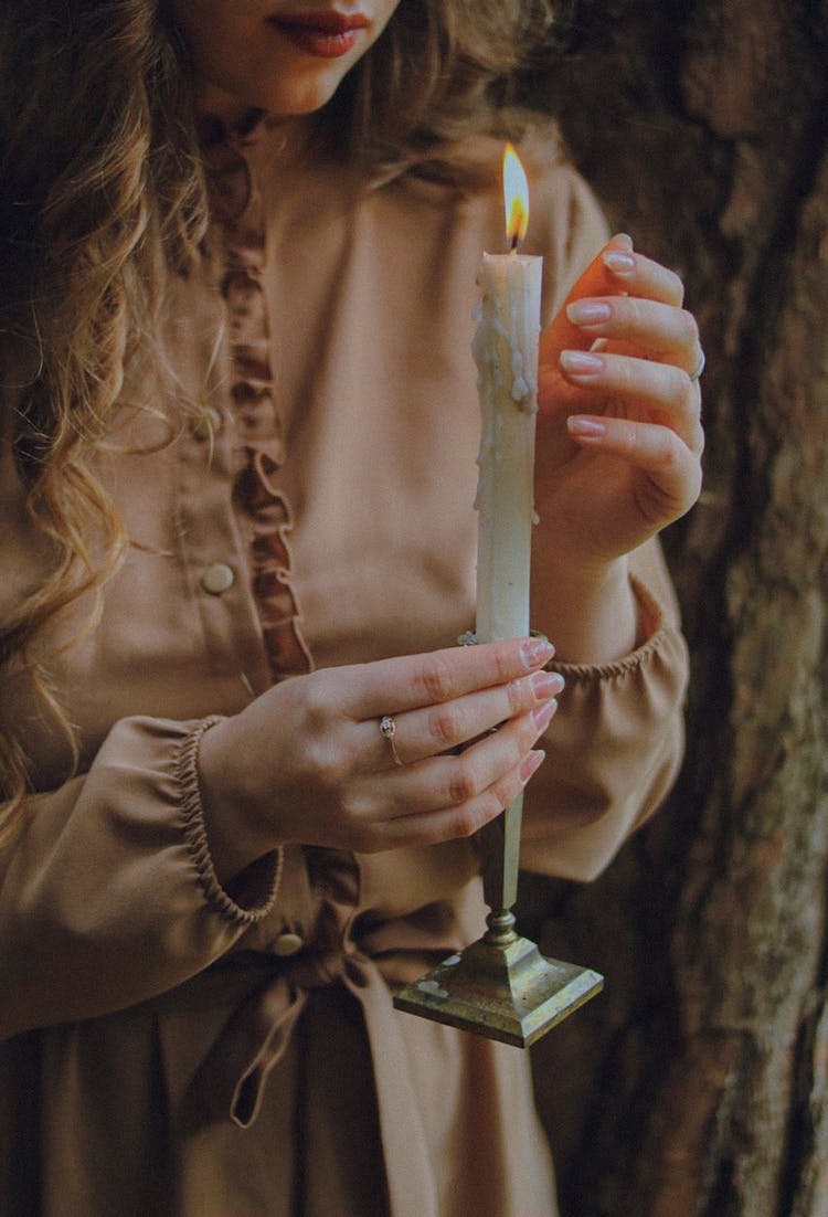 Woman Holding A Burning Candlestick