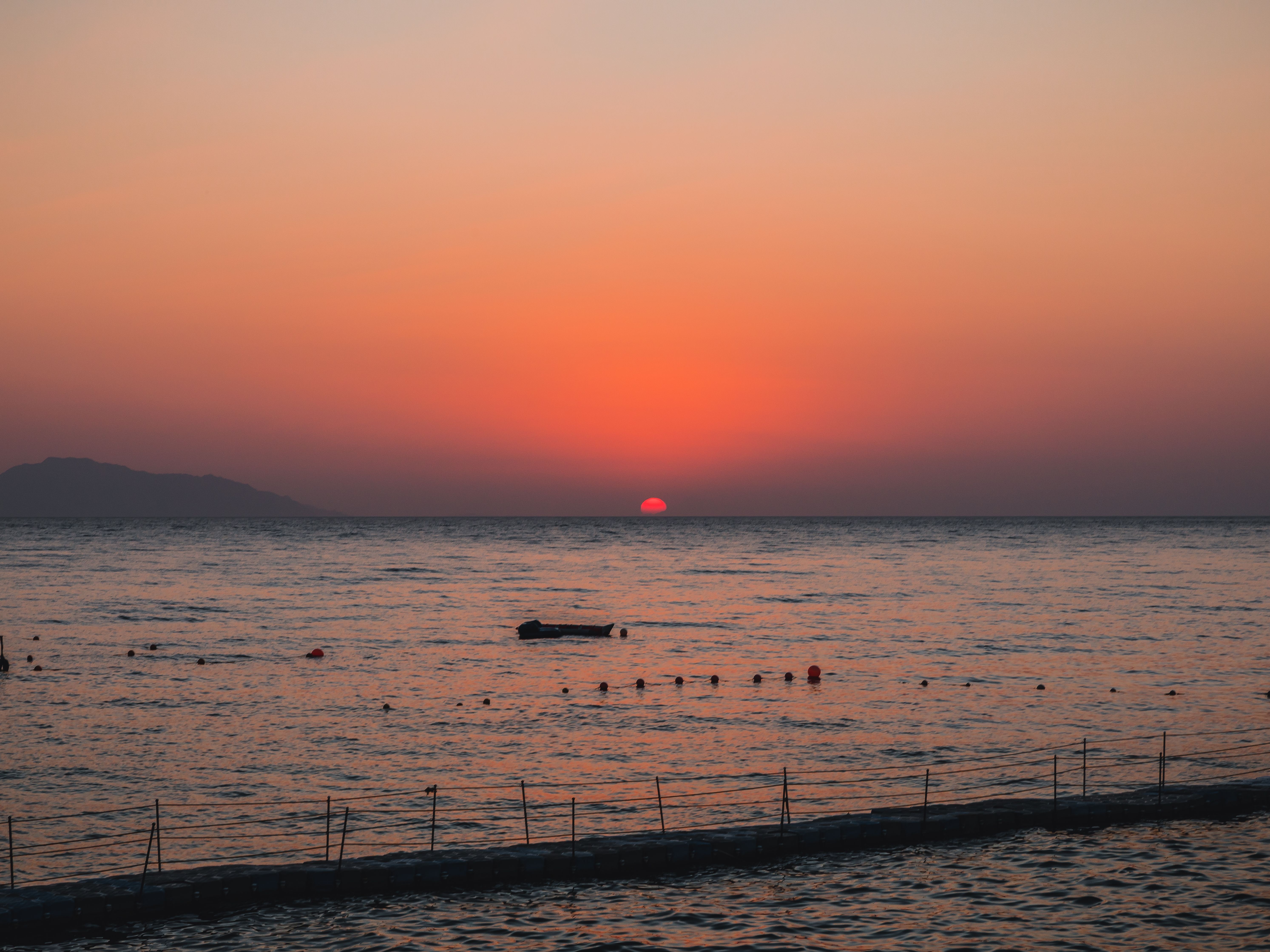 Red Sun Setting Behind the Horizon Over the Sea · Free Stock Photo