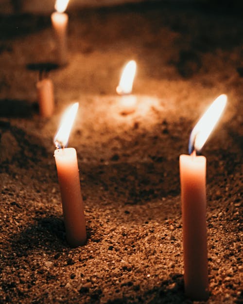 Lit Candles Stuck in the Sand