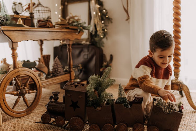 Boy Playing With Wooden Train Toy During Christmas