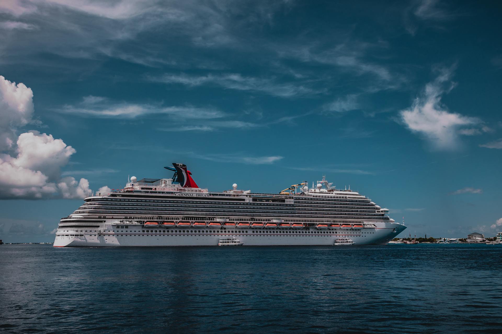A stunning view of a luxury cruise ship sailing on calm seas under a bright blue sky.