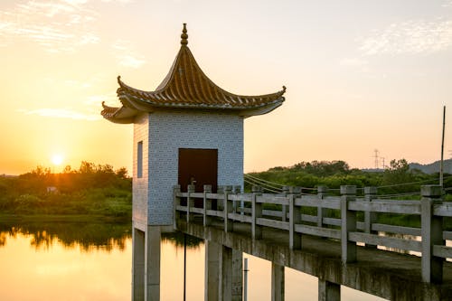 Pavilion at the End of the Concrete Pier on a River at Sunset