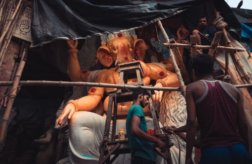Free Artisans skillfully work on a large Ganesha statue in Kolkata, showcasing traditional Indian sculpture techniques. Stock Photo