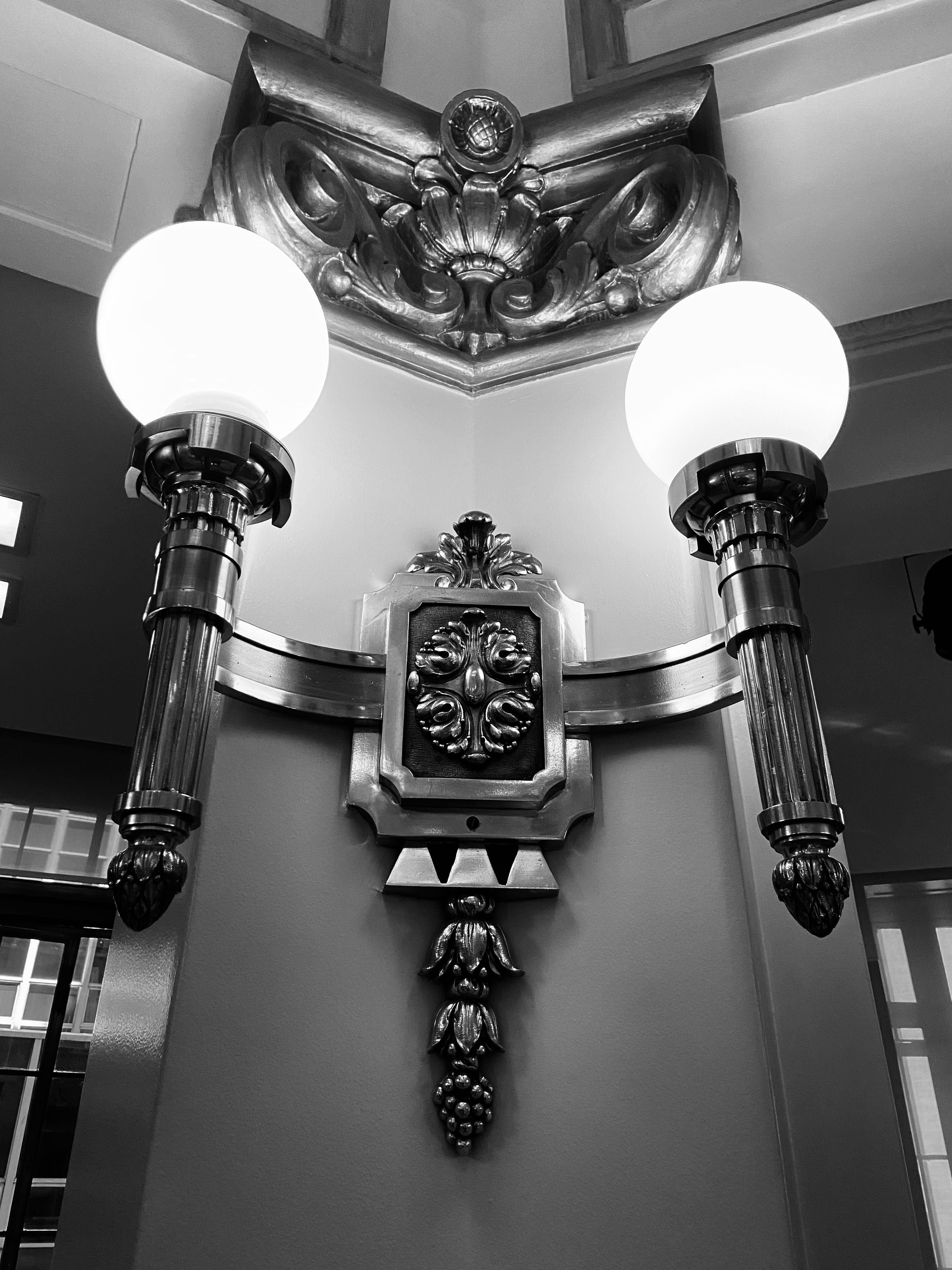Black and white photo of an elegant Art Deco metallic wall sconce in Sao Paulo, Brazil.. pexels, black, white