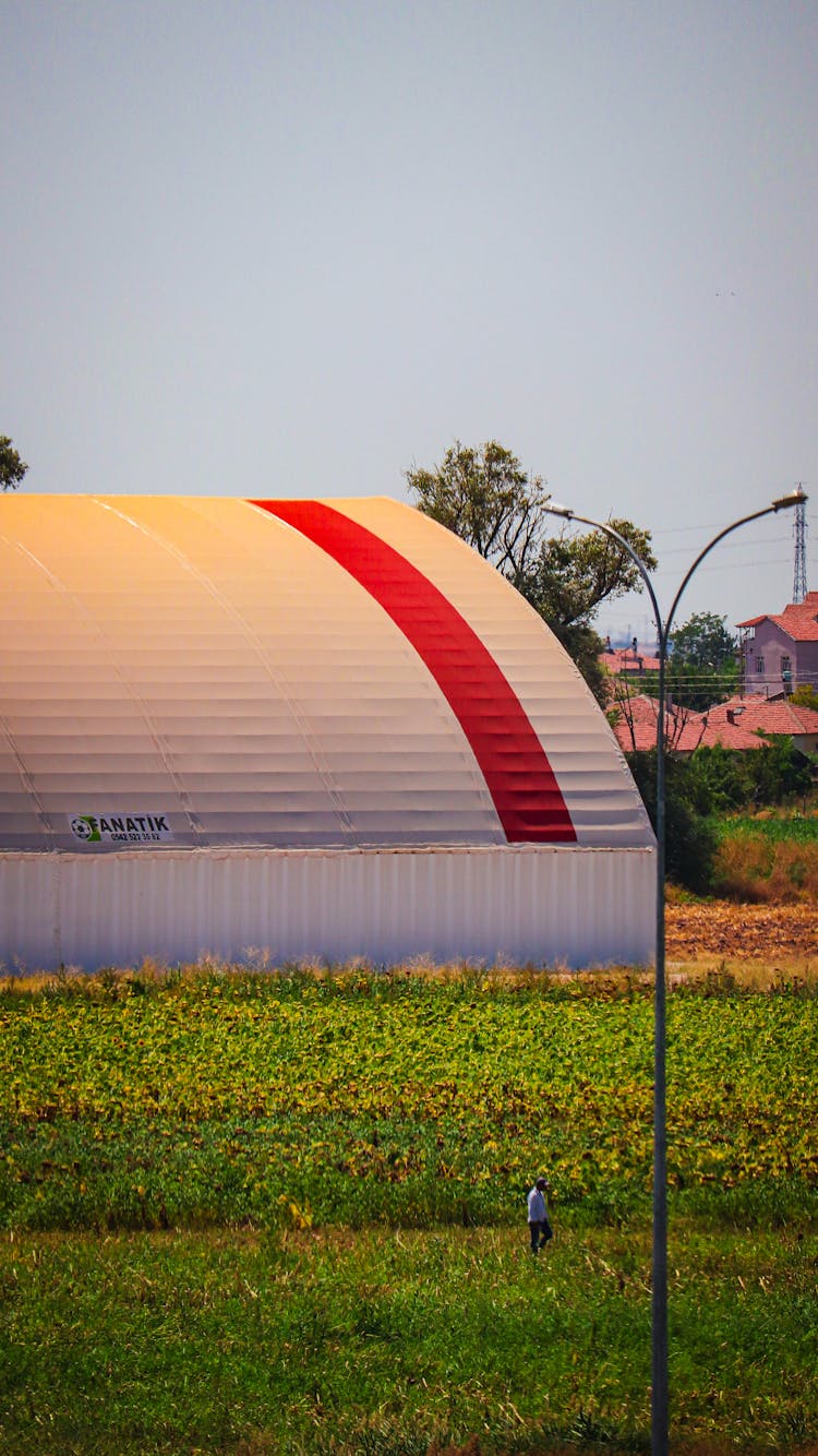 A Cropland And A Farm Building 