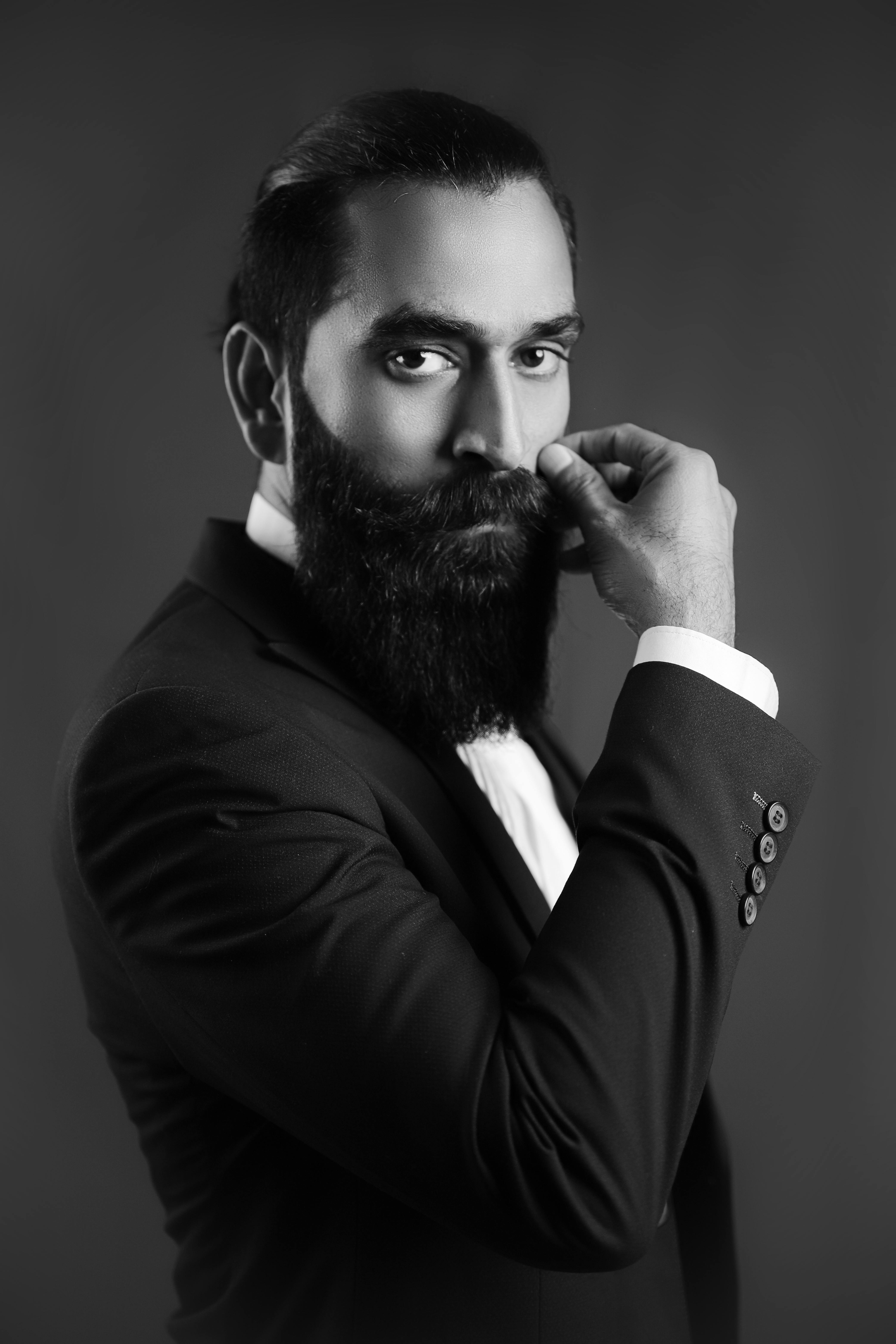 Gratis El Tipo Barbudo Con Camisa Blanca Y Chaleco Negro Está Sobre Fondo Negro. Foto de stock