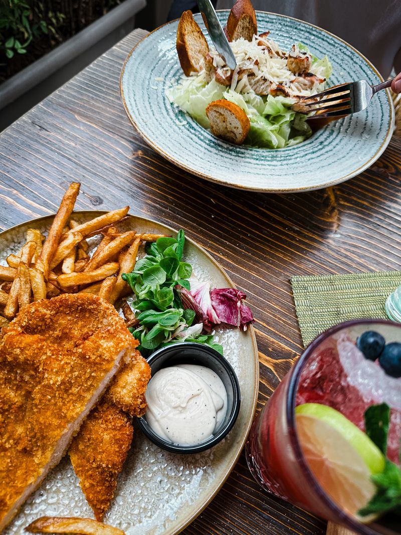 Illustrative restaurant meal with fries, salad and a drink; not the Palm Tree Club dish
