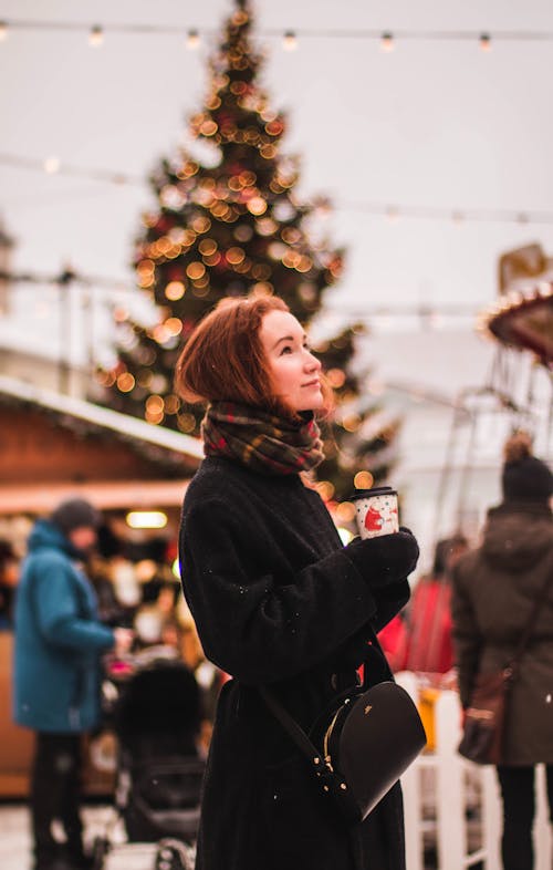 Woman Wearing Black Coat While Holding Cup