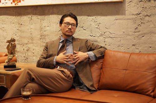 Elegant Man in a Suit Sitting on a Leather Couch
