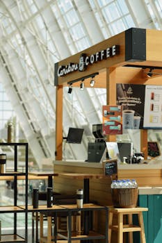 Contemporary coffee stand in a mall with modern architecture and coffee offerings.
