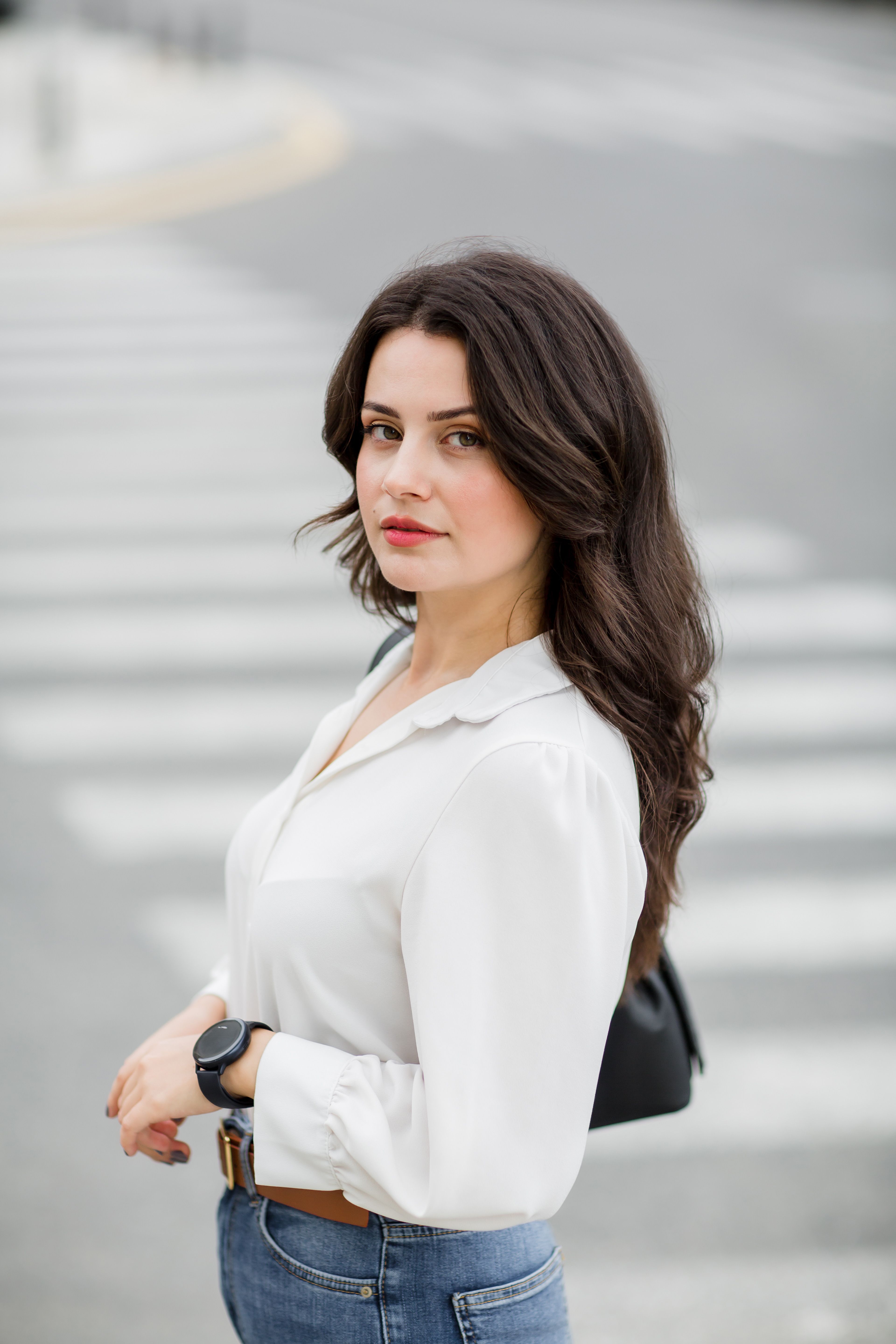 Young Woman in a White Shirt Posing on the Street · Free Stock Photo