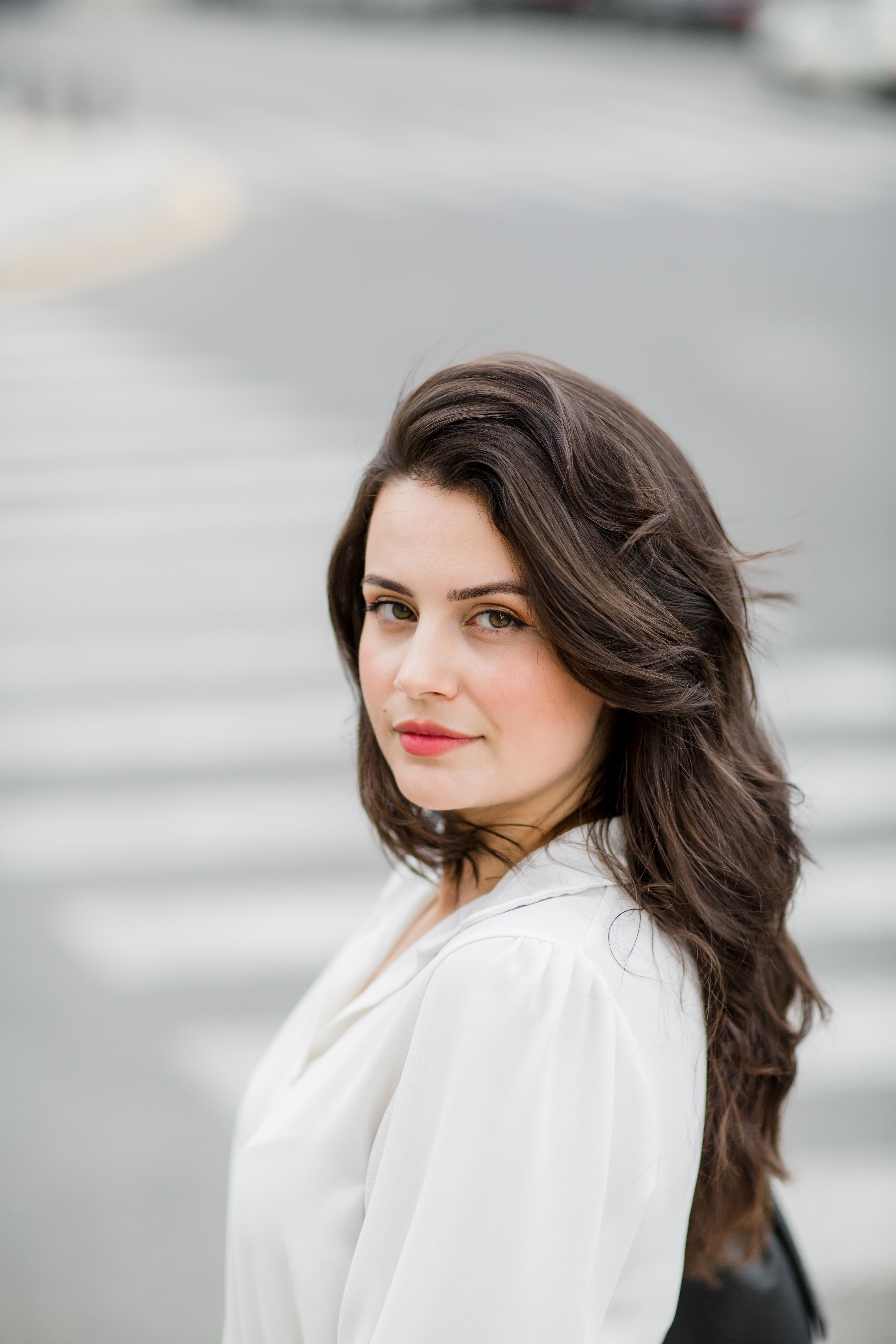 Young Woman in a White Shirt Posing on the Street · Free Stock Photo
