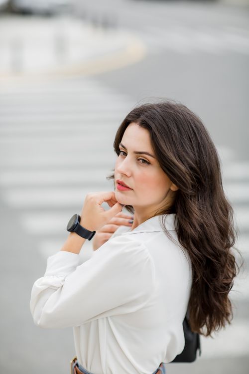 Young Woman in a White Shirt Posing on the Street · Free Stock Photo