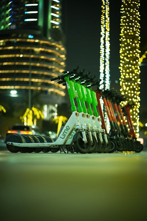 Electric Scooters Parked in a Row on the Sidewalk in City