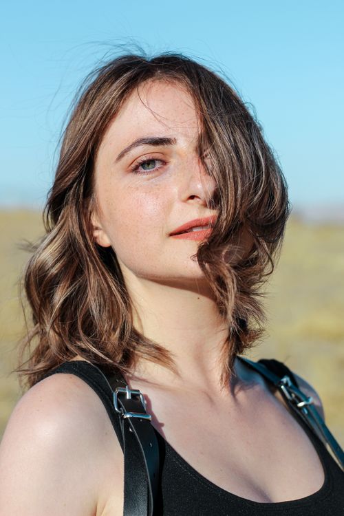 Free Portrait of a young woman enjoying a sunny day outdoors with natural sunlight. Stock Photo