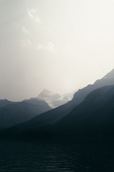 Dramatic sunrise over the misty mountains of Banff, Canada, creating a serene and picturesque landscape.