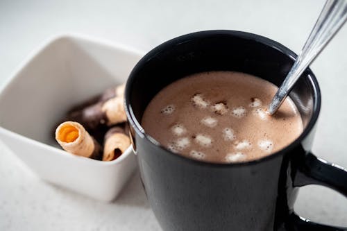 Hot Choco Em Caneca Preta Ao Lado Da Tigela Branca