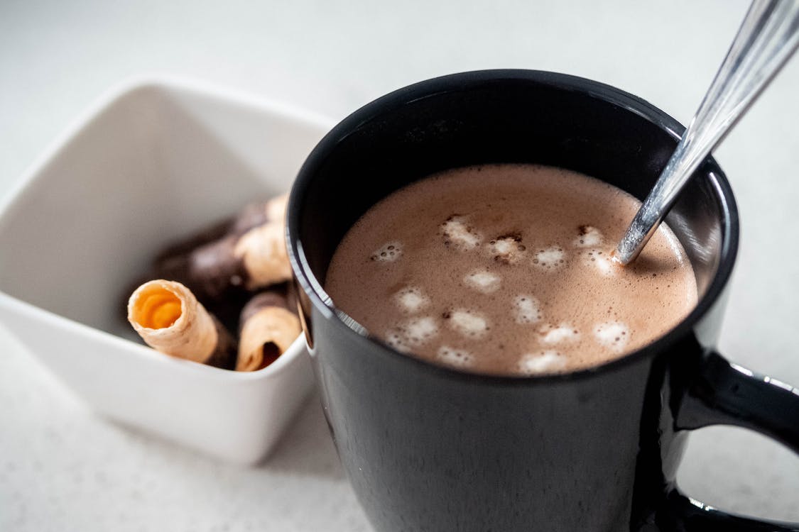 Hot Choco in Black Mug Beside White Bowl