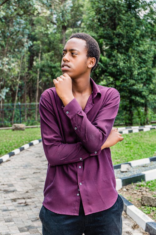 Young Man in a Shirt Standing on the Pavement in the Park