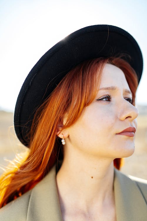 Young Redhead Wearing a Hat and Standing Outside