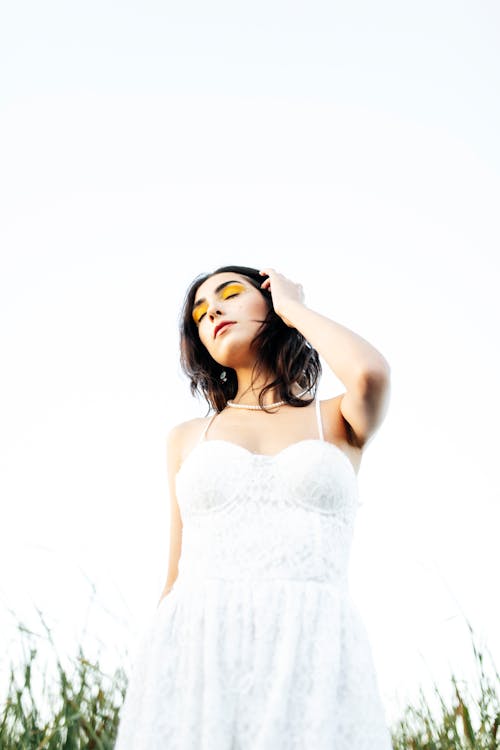 Brunette Woman Posing in White Dress