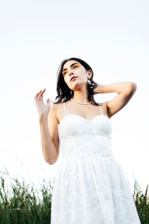 Young Woman in a White Dress Standing Outside