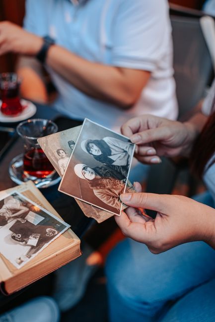Close-up of hands holding vintage photographs with a nostalgic touch.