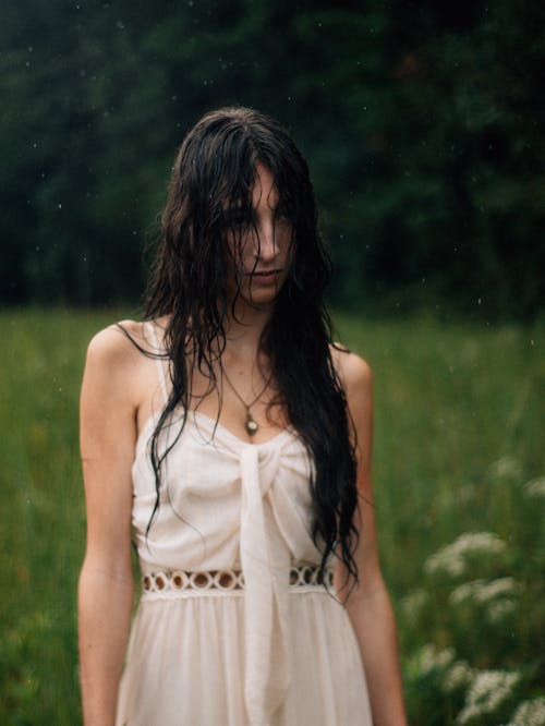 Woman with Wet Hair, Posing in a White Summer Dress on a Green Field