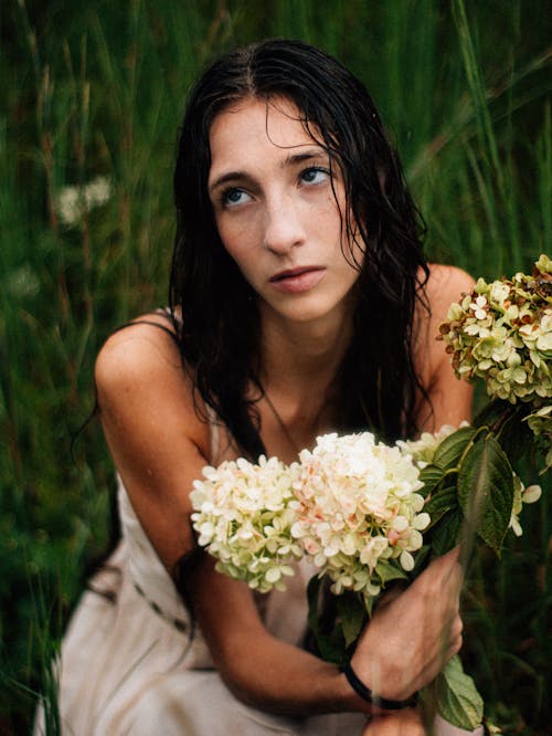 Photo of a Brunette with Wet Hair, Posing in a Meadow with Hydrangeas