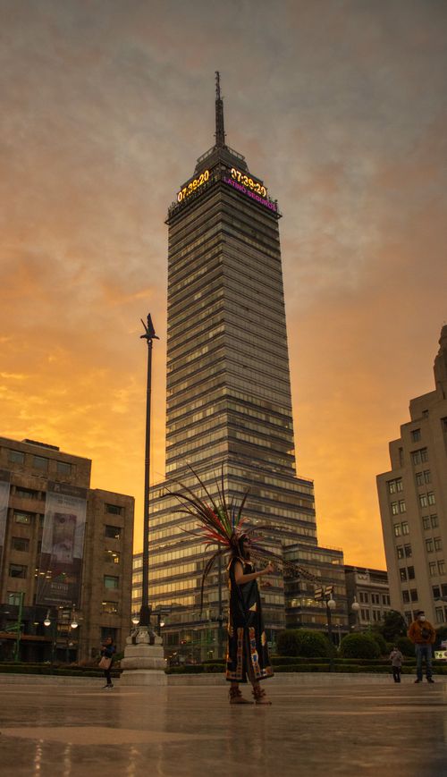 Free Street performer in front of Torre Latinoamericana at sunset in Mexico City. Stock Photo