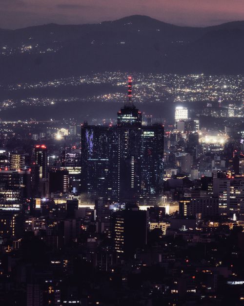 Free A breathtaking aerial shot of Mexico City's skyline illuminated against a dusky backdrop. Stock Photo