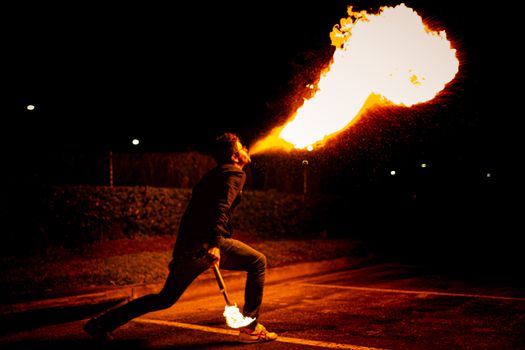 Blazing fire show performed at night by a skilled fire breather.