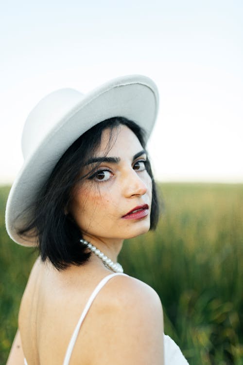 Young Woman Wearing a Hat Posing on a Field 