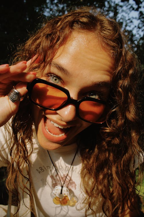 Portrait of Woman with Curly Hair Wearing Sunglasses