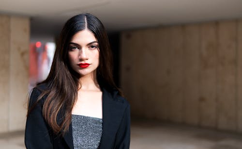 Photo of a Young Brunette Wearing a Red Lipsticks and a Black Jacket 