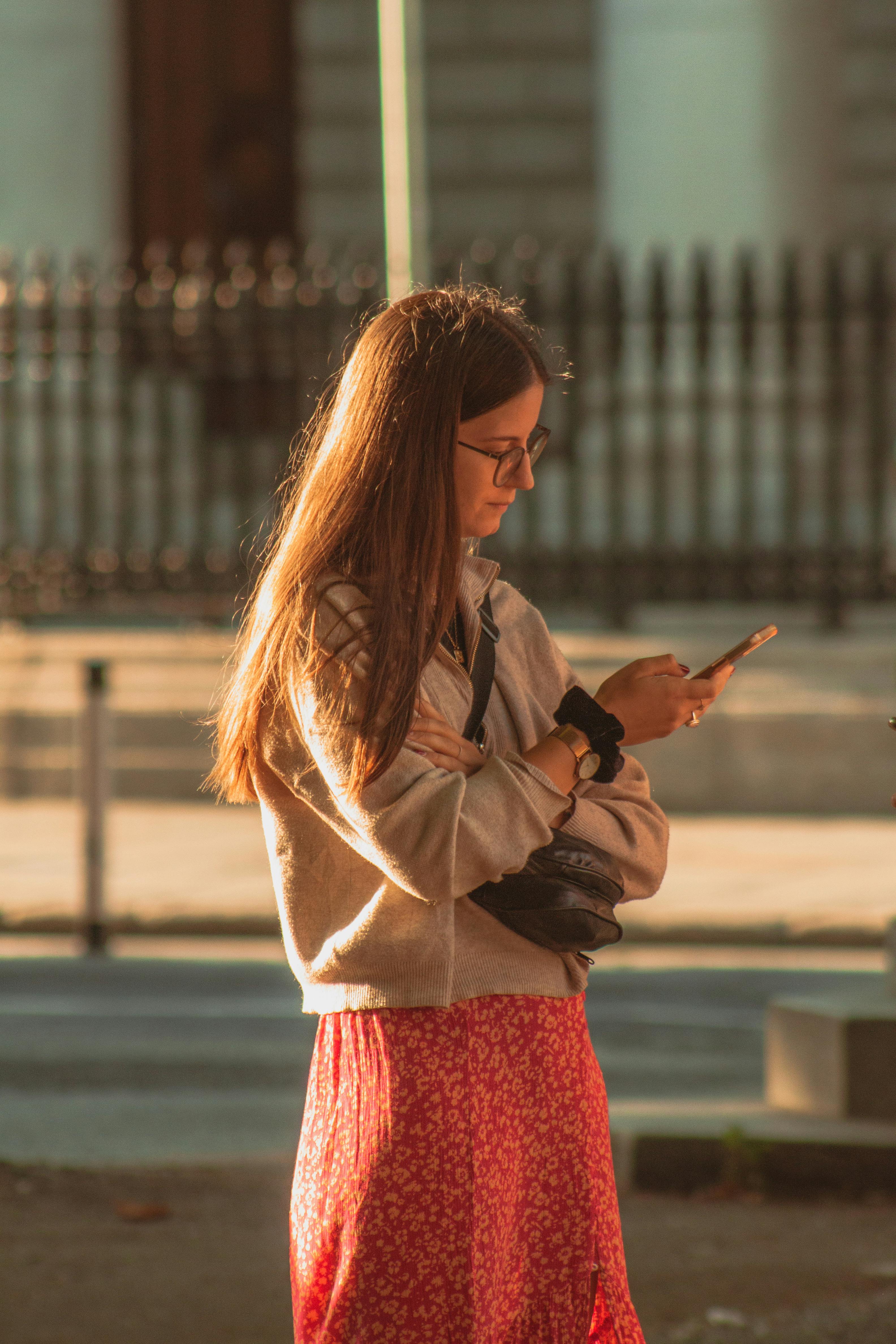 woman with smartphone in the light of the setting sun