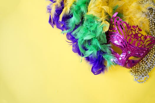 A vibrant Mardi Gras mask with colorful feathers and beads on a yellow background.