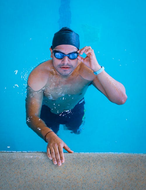 Swimmer Standing in the Pool and Fixing his Goggles 