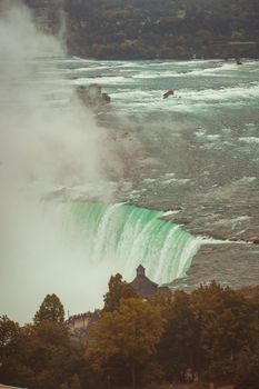 A breathtaking aerial view of Niagara Falls with mist and surrounding landscape.