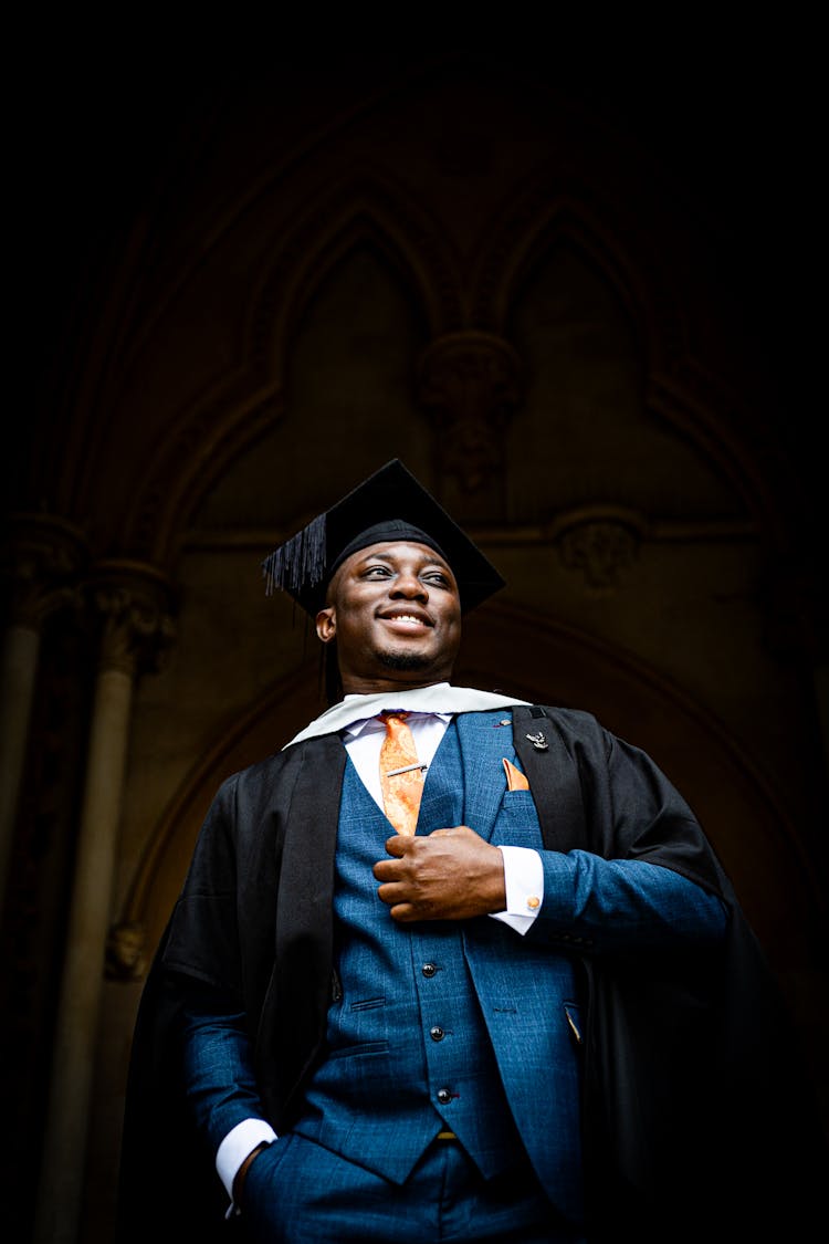 Graduate In Academic Regalia And Blue Suit