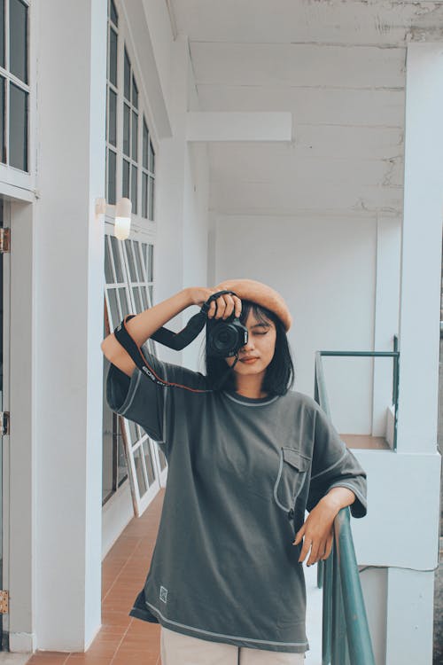 A Young Woman Taking a Photo on a Balcony