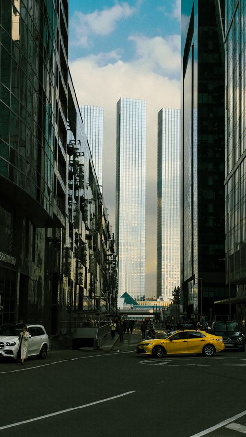 Free Vibrant city street view featuring towering glass skyscrapers and bustling traffic. Stock Photo