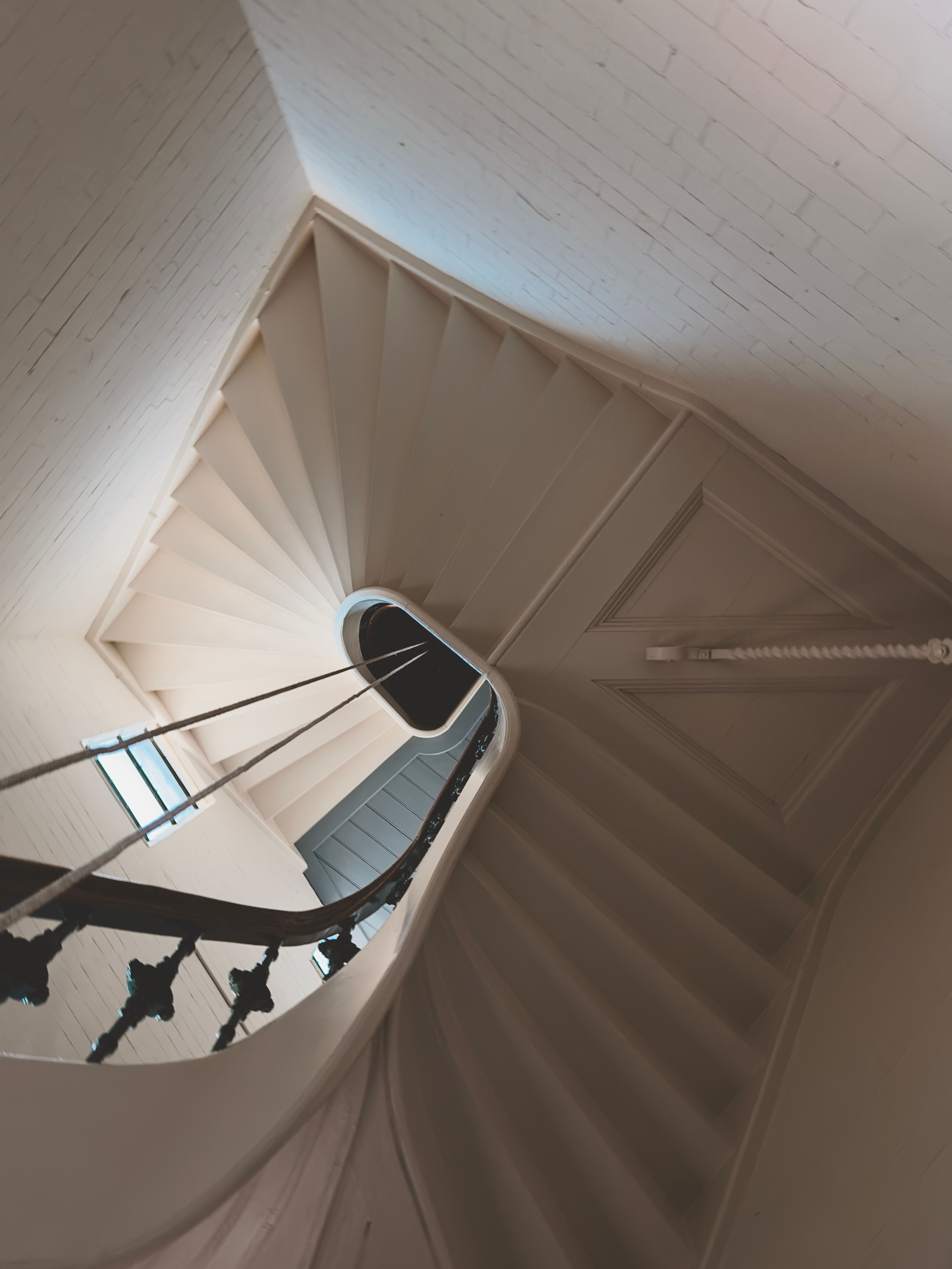 A beautifully designed curved staircase in a historical Dutch house interior, captured from above.