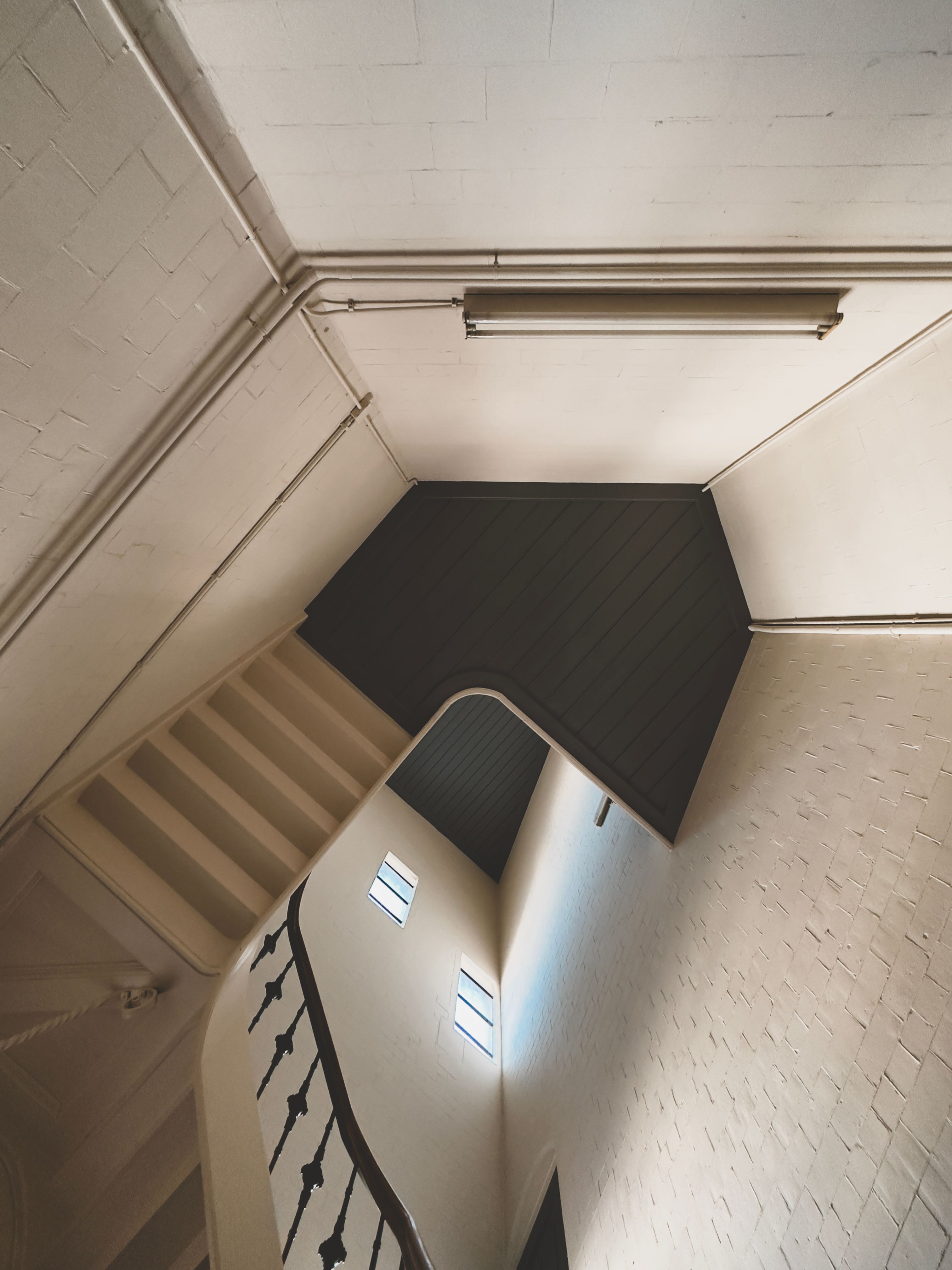 Artistic view of a staircase with railings and geometric design indoors.