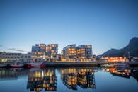 黄昏时分，现代建筑在平静的海滨被照亮，倒映在水中，展现了斯堪的纳维亚建筑的特色